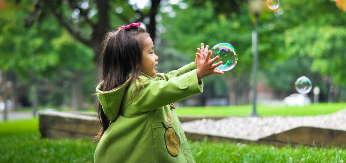 selective photo of a girl holding bubbles