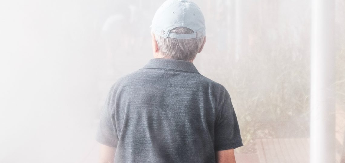 man walking towards smoke-covered building